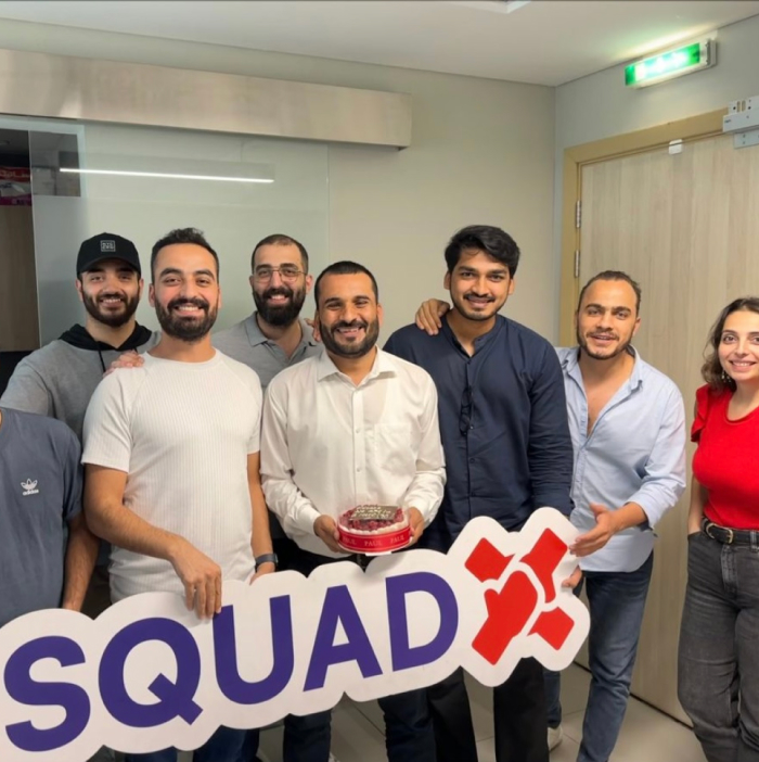 With the Squad X team, holding a Squad X sign